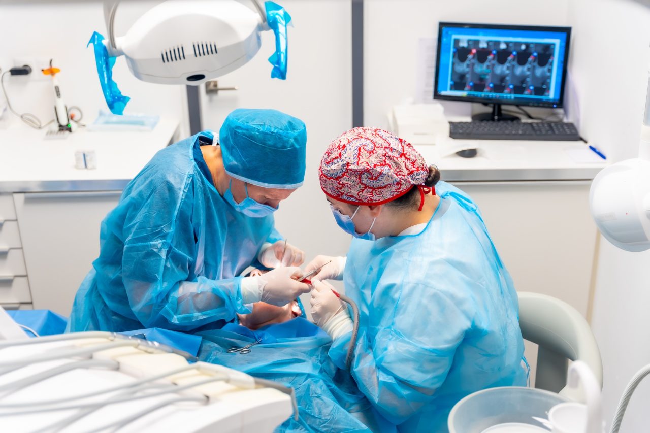 Centro Recanto das Garças 12 female dentists in blue scrubs performing a complicated operation on a female patient sucking blood
